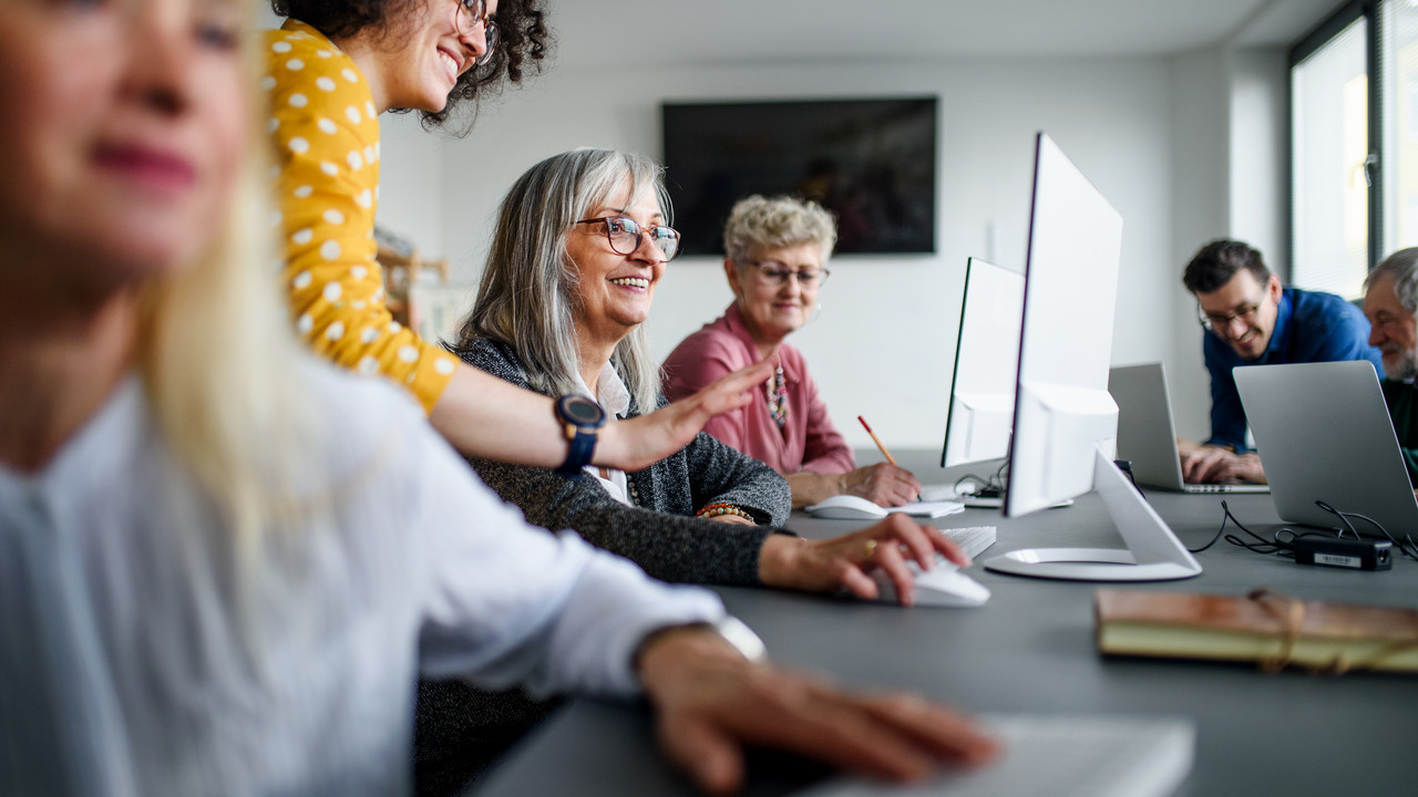 Group of senior people attending computer and technology education class.