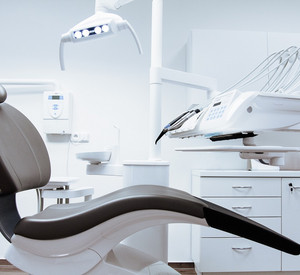 Behandlungsraum einer Zahnarztpraxis mit leerem Behandlungsstuhl.