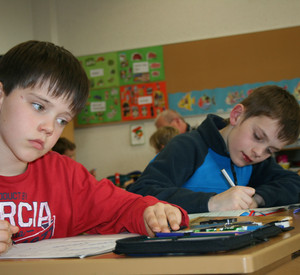 Zwei Jungs schreiben in der Schulklasse