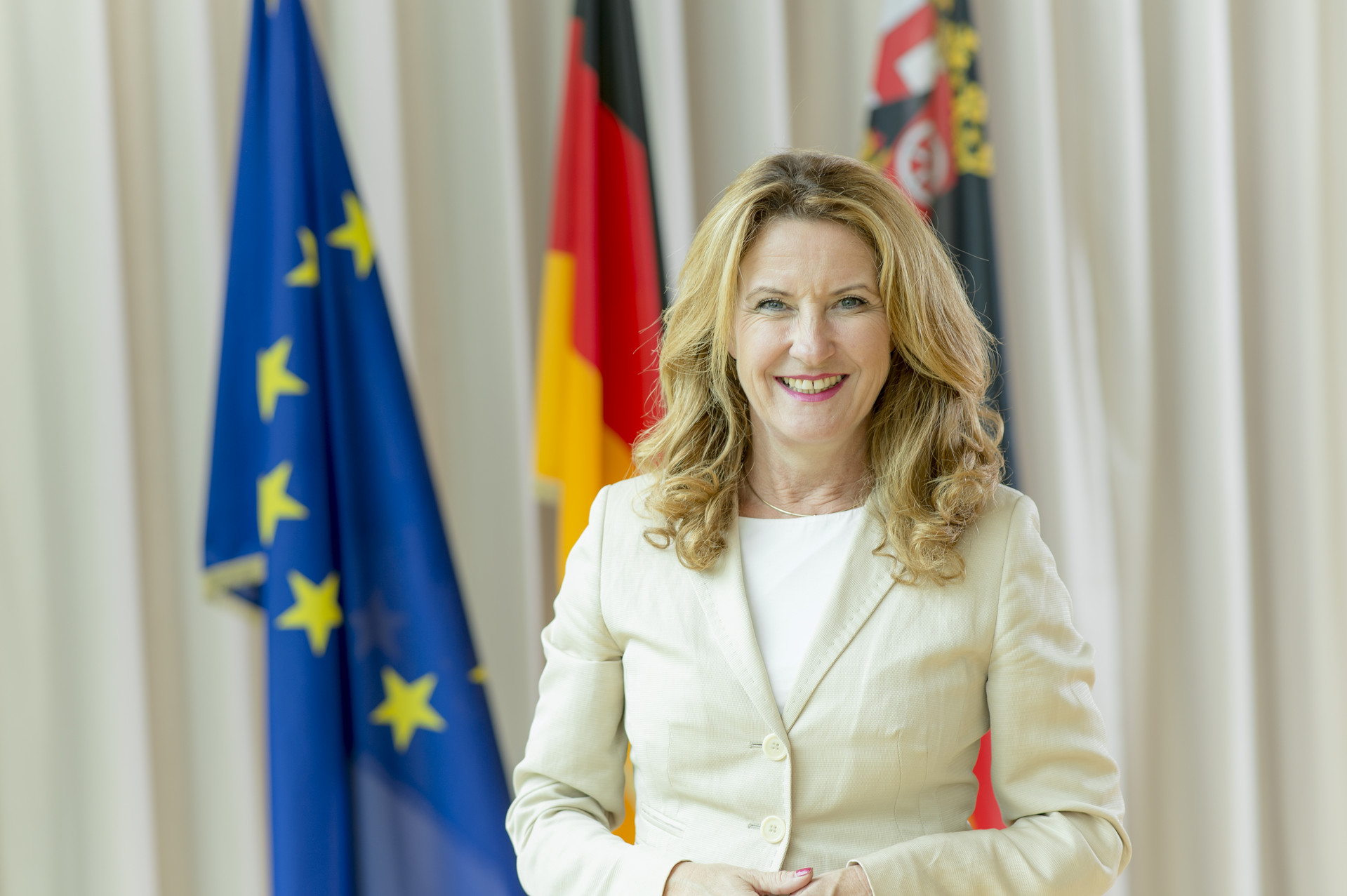 Portraitfoto der Staatssekretärin Heike Raab vor Europa- und Rheinland-Pfalz-Fahne