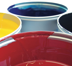 Nahaufnahme von weißen Farbeimern gefüllt mit gelber, schwarzer, roter und blauer Farbe.